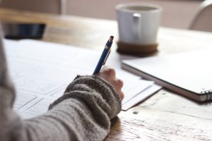 Student under eksamen som skriver svar på papir